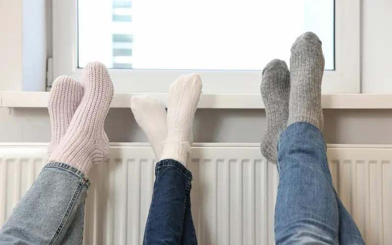 Family warming their feet on a radiator